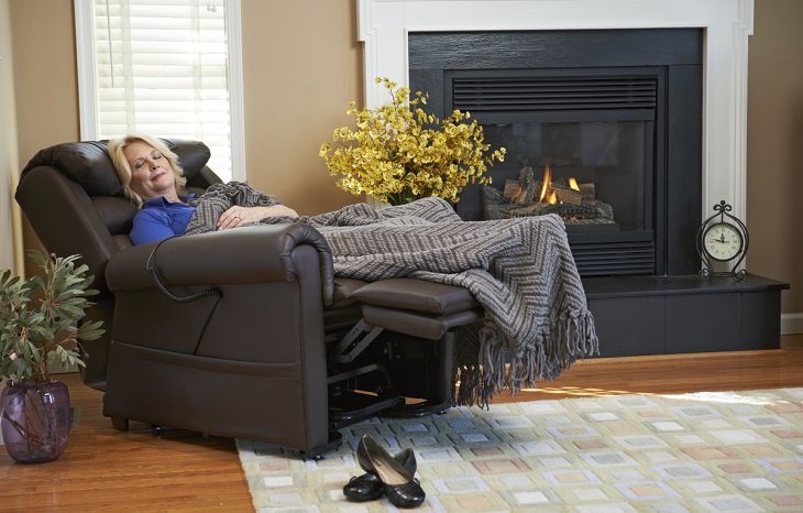 woman sleeping in lift chair next to fire